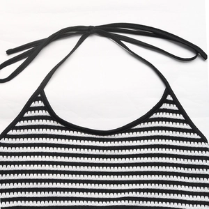 Detail of black and white striped knit halter top featuring back neck tie closure