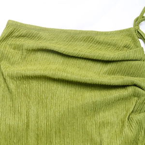 Dettaglio del tessuto a pieghe verde con coulisse laterale per il set estivo moda