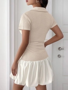 Detailed view of the beige waffle knit top and shiny white satin pleated skirt texture