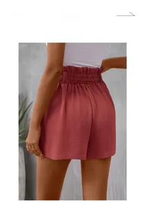 Detail view of brick red paperbag waist shorts with elegant tie belt from the back