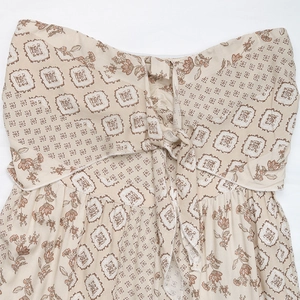 Detailed view of tie-knot neckline and ethnic floral print on strapless jumpsuit