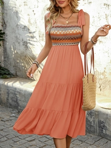 Close-up of bohemian tiered maxi dress featuring geometric embroidery and shoulder ties