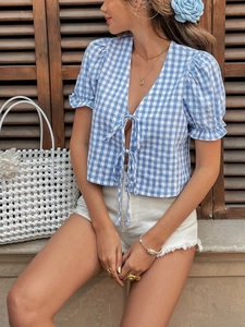 Detail of blue gingham crop top featuring double tie-front bows and ruffled cuffs
