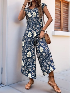 Detail of summer wide-leg jumpsuit featuring vintage leaf and daisy prints in navy blue