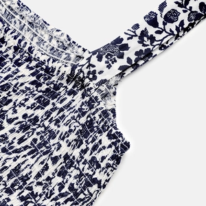 Detail of smocked bodice and floral print on white summer dress with wide straps