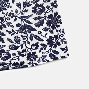 Close-up of dark blue floral print fabric with high-quality hemmed edges on summer dress