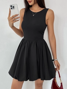 Close-up of black sleeveless mini dress featuring ribbed top and puffy bubble skirt