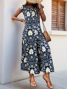Detail of bohemian summer jumpsuit featuring maple leaf and daisy prints on navy blue fabric