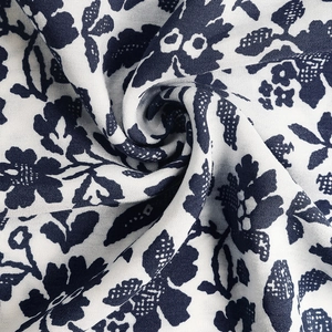 Close-up of white floral printed cotton linen fabric with navy blue flower patterns