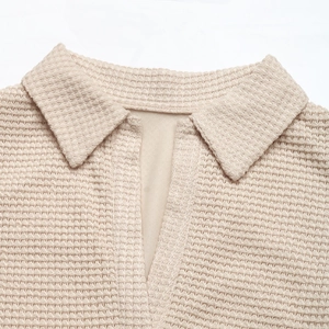 Detail shot of beige waffle texture fabric on a V-neck polo collar summer dress