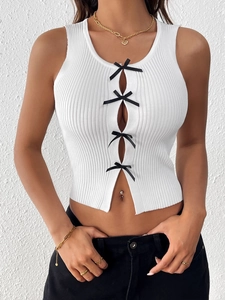 Vue détaillée du crop top blanc en maille côtelée avec quatre nœuds en soie noire