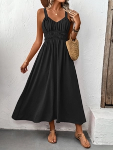 Detail of black smocked bodice on V-neck sleeveless maxi dress with textured fabric