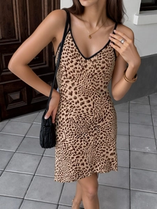 Détail de mini robe léopard avec décolleté en V profond et fines bretelles noires