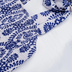 Detailed view of smocked elastic bodice with blue floral print and adjustable shoulder straps