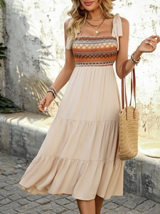 Detail of smocked bodice and adjustable tie straps on a bohemian tiered maxi dress
