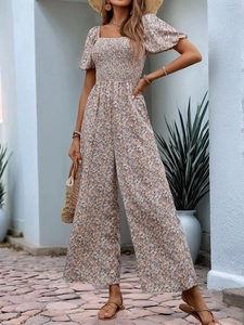 Detail of smocked bodice and square neck on floral wide leg jumpsuit with puff sleeves