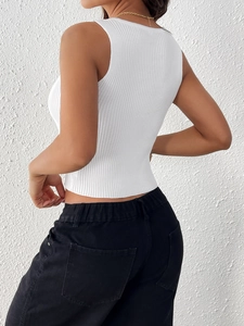 Détail de la texture en maille côtelée blanche et coupe ajustée du débardeur femme