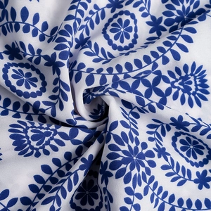 Close-up of blue floral wreath print on white fabric with textured folds for summer dress