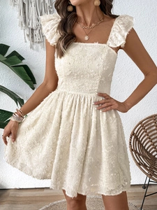 Close-up of white mini dress featuring 3D floral textures and ruffled flounce sleeves