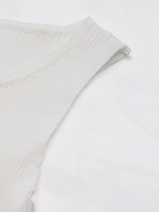 Gros plan sur la maille côtelée blanche montrant la texture fine et les détails de couture