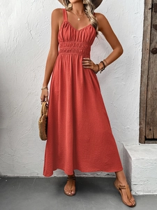 Detail of coral red maxi dress featuring a high elastic waist and textured fabric finish