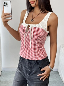 Close-up of red plaid camisole with white ruffled neckline and cute bow-tie details