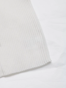 Gros plan sur un tissu en maille côtelée blanche montrant la texture et les détails