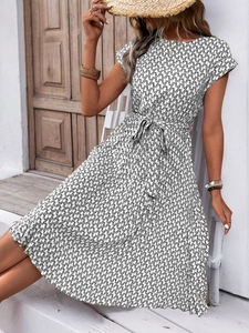 Detail of summer dress featuring black and white geometric print and waist tie belt