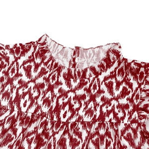 Close-up detail of ruffled stand collar and abstract red print on beach dress