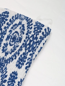Détail de la poitrine smockée sur une combinaison fleurie bleue pour femmes en été