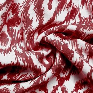 Detailed macro view of the soft red and white floral print fabric texture and drape