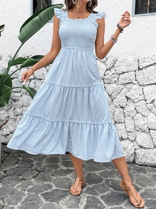 Detail of tiered skirt layers and smocked bodice on blue striped summer maxi dress
