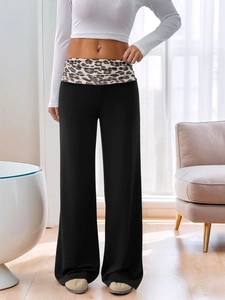 Détail de la taille patchwork léopard sur un pantalon noir à jambes larges taille basse