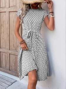 Detail of the black and white geometric print dress with waist tie and pleated hemline