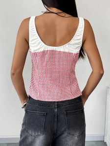 Detail of a slim-fit backless tank top featuring white paneling and red gingham pattern