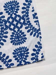 Gros plan de la broderie florale bleue et de la texture sergée du combipantalon