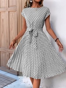 Detail view of the black and white geometric print and tied waist on the pleated dress