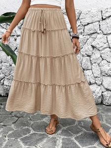 Detail of khaki layered A-line maxi skirt featuring elastic waist and drawstring
