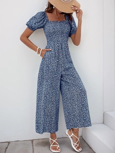 Détail de combinaison à fleurs bleu marine avec manches bouffantes et col carré chic