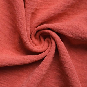 Macro shot of brick red textured fabric with natural crinkles and fine woven patterns