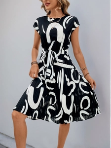Detail of elegant black and white pleated dress with abstract print and waist tie