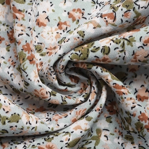 Detail of mint green floral fabric with peach blossoms and delicate light texture