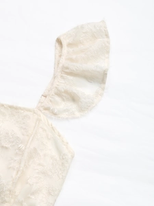 Detail of white mini dress featuring luxury faux fur texture and delicate ruffle trim