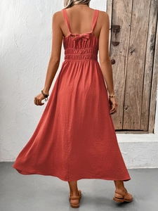 Detail of terracotta smocked waist dress with decorative back bow tie design