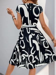 Detail of pleated hem and geometric print on a women's short-sleeve summer dress