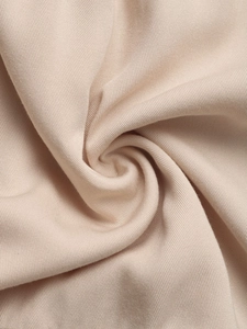 Detailed macro view of high-quality light beige twill fabric texture for summer dresses