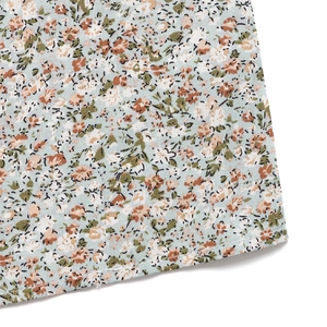 Detail of floral print fabric with high-quality hem stitching on a light blue jumpsuit