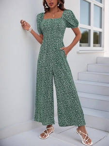 Close-up of floral print jumpsuit featuring puff sleeves and square neck in dark green