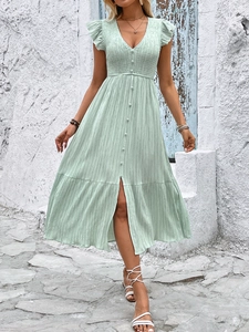 Detail of light green V-neck dress featuring button accents and textured summer fabric