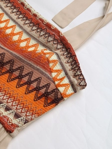 Detail of bohemian wavy embroidery and beige strap on a summer sundress